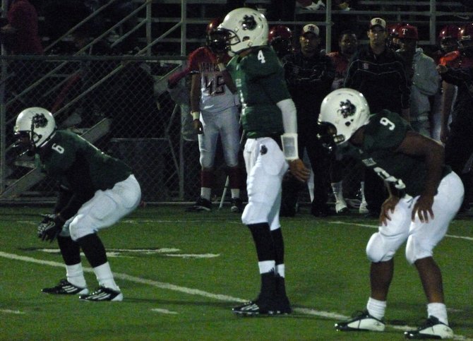 Helix quarterback Brandon Lewis flanked in the shotgun by running backs Darrion Hancock (6) and Michael Adkins (9)
