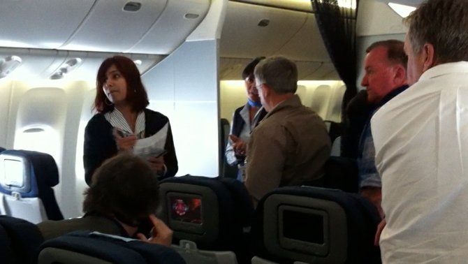 A flight attendant shuffling passengers