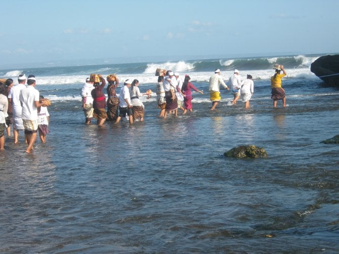 Devotees carry offerings to the Tanah Lot Temple in Bali.