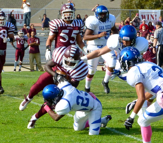 Kearny running back Todd Steven absorbs a hit from San Diego defensive back Zion Fulani