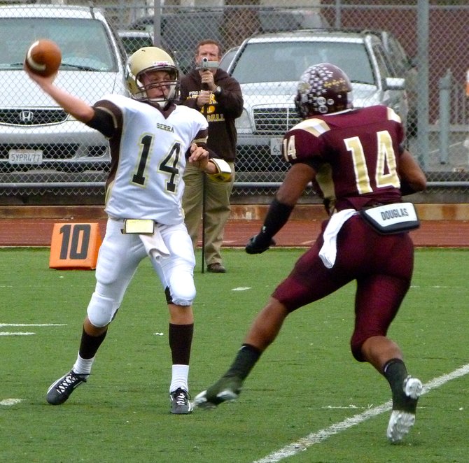 Serra quarterback Hunter Correll fires a pass with Point Loma defensive end Tevin Heyward closing in
