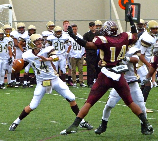 Serra quarterback Hunter Correll throws a pass from the pocket over outstretched Point Loma defensive end Tevin Heyward 