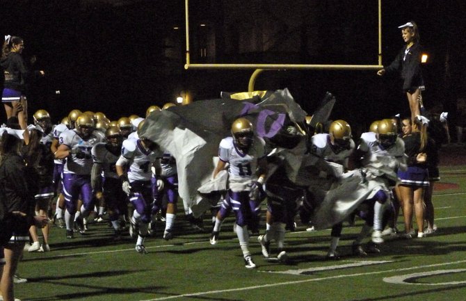St. Augustine players bust through the banner at halftime