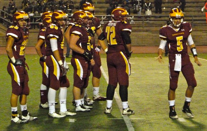 Torrey Pines quarterback Andrew Perkins looks to the sideline for the play call with his Falcons teammates waiting in the huddle