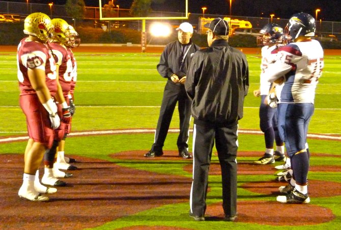 Mission Hills and Steele Canyon team captains meet at midfield for the coin toss