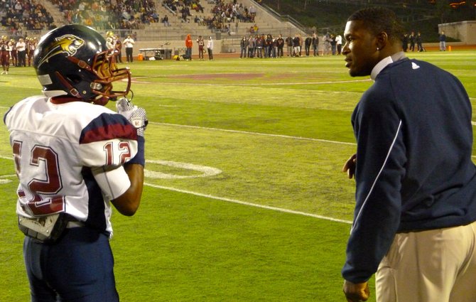 Steele Canyon defensive back Ricky Francis gets instruction from a cougars coach along the sidelines