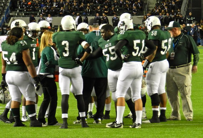 Helix huddles up around head coach Troy Starr during a timeout