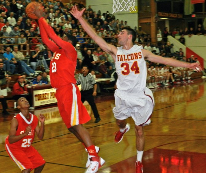 Cathedral Catholic forward Xavier Williams hauls in a rebound in front of Torrey Pines forward Sean Milmoe
