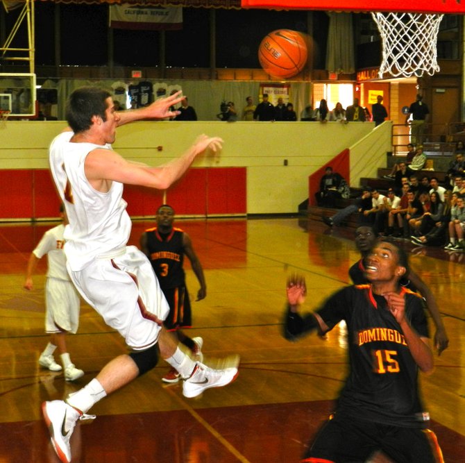Torrey Pines guard Joe Rahon fires a pass across the lane over the head of Dominguez guard T.J. Traylor