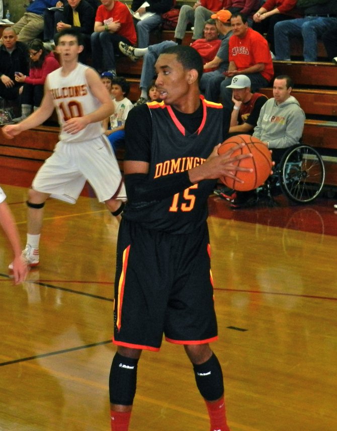 Dominguez guard T.J. Traylor shields the ball from Torrey Pines defenders in the backcourt