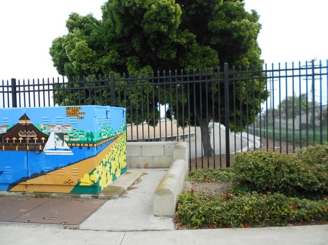 Colorful utility box with Point Loma Sewage Treatment Center in the background.