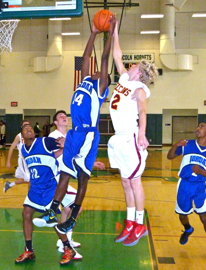 Jordan guard Deontae North pulls down a rebound in front of Torrey Pines guard Alec Wulff