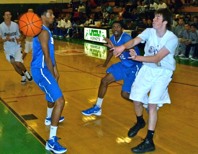 St. Augustine guard Brent Jones fires a pass past a pair of Serra defenders into the lane