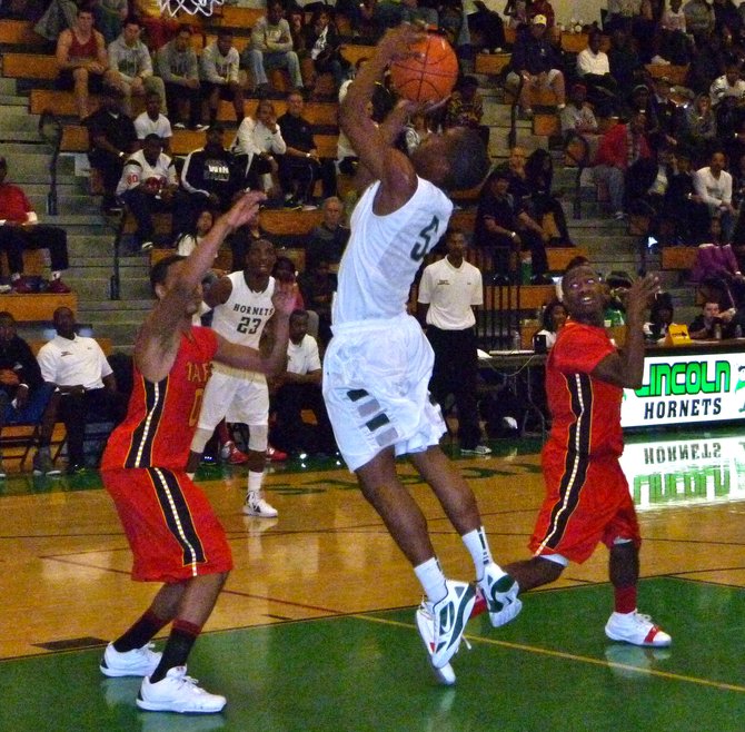 Lincoln guard Steve Martin goes up for a shot in the lane between two Taft defenders