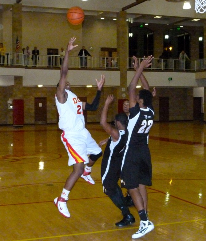 Cathedral Catholic forward Xavier Williams puts up a one-handed shot in the lane over two Mission Bay defenders