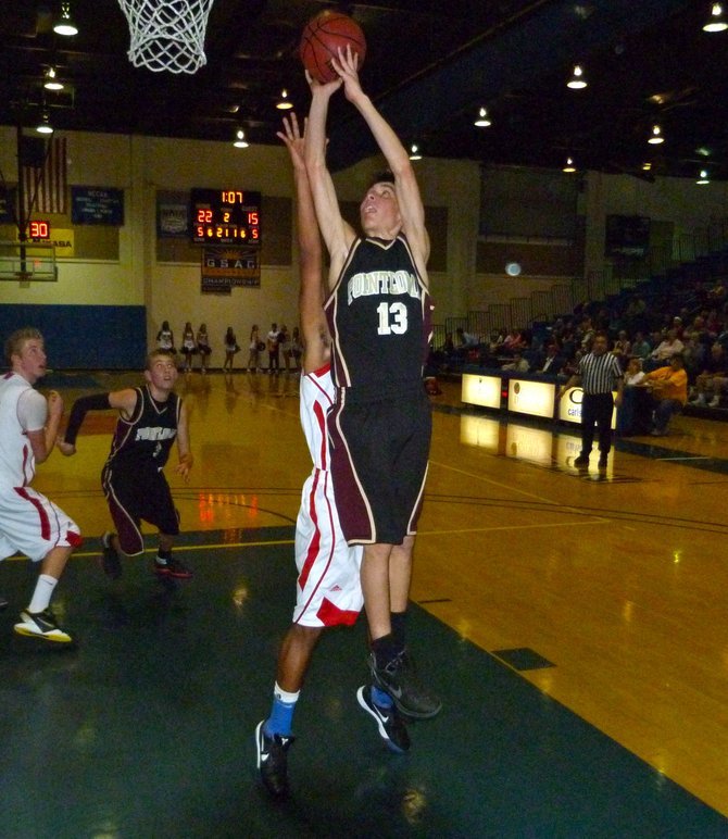 Point Loma guard Dillon Fitzmorris puts up a shot in the key in front of a Christian defender