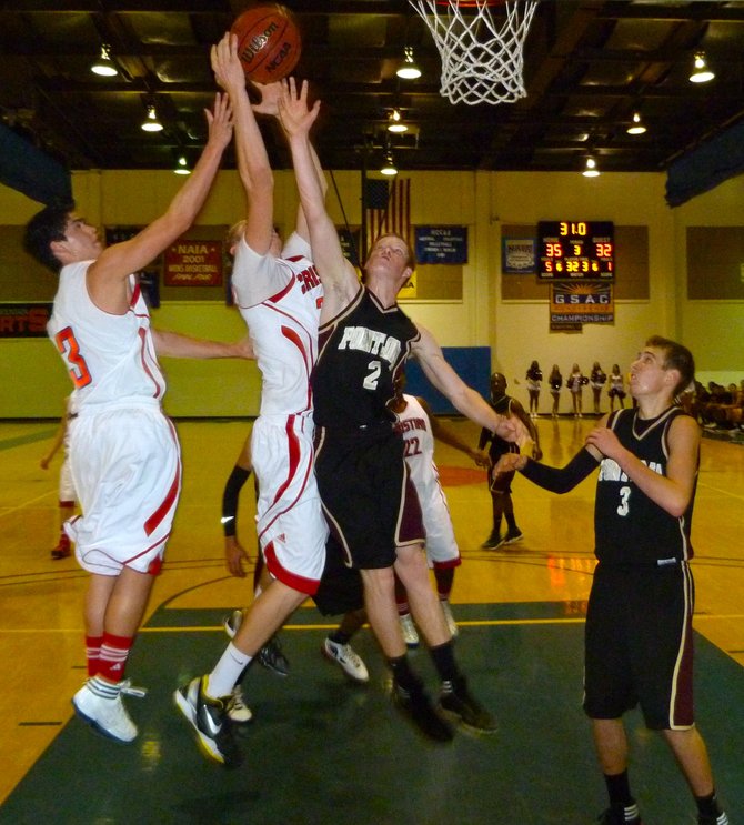 Christian forward Shane Dillon gets up to grab a rebound over Point Loma guard Daniel Enright