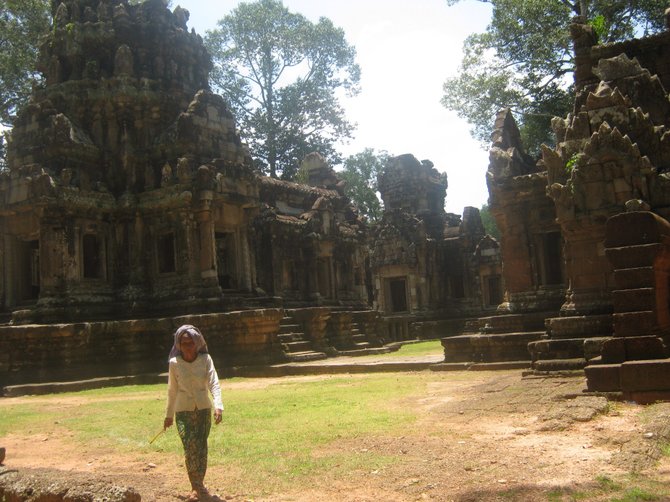 A Cambodian woman strolls in front of the Banteay Kdei temple near Siem Reap, Cambodia.