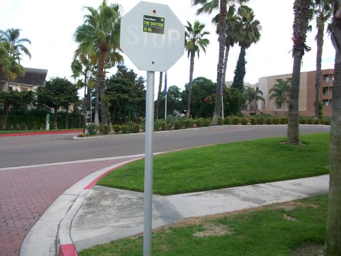 Weathered stop sign near Barnes Tennis Center driveway.