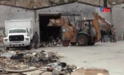 A backhoe removes garbage from a Tijuana warehouse

*Still image from uniradioinforma.com video report*