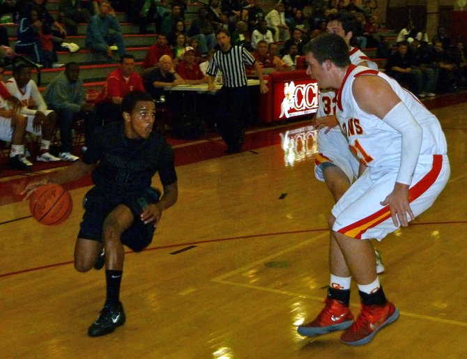 Lincoln guard Keone Spates dribbles on the perimeter with Cathedral Catholic forward Brendan Reh defending