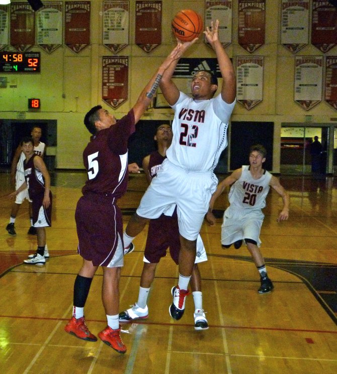 Vista forward Patrick Johnson hangs in the air over Sweetwater forward Junior Bautista for an off-balance shot