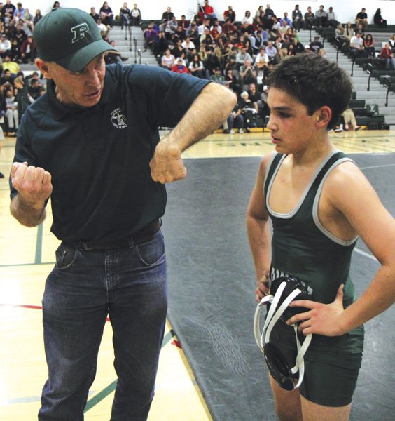 Head coach Wayne Branstetter reviews 
holds with 106lb class wrestler Manny Lair