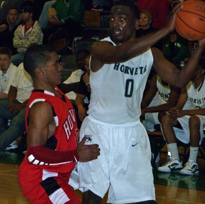 Lincoln guard Tyrell Robinson protects the ball from the defensive pressure of Hoover guard Chris Jones