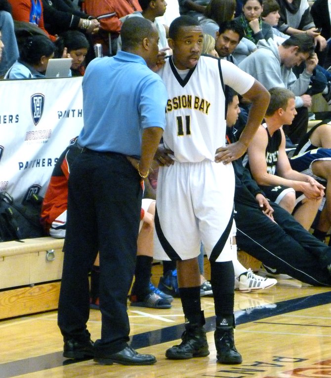 Mission Bay guard Jerald Albritton listens to San Ysidro head coach Terry Tucker during a timeout
