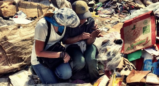 Volunteer comforting a child, one of Tijuana's destitute poor living at the Montana de Basura. 