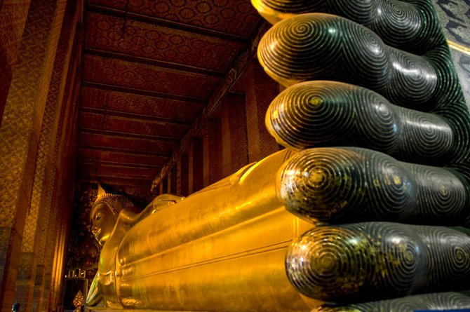 This is the largest indoor representation of Buddha in the world. It is located in Wat Pho, along the Chao Phraya river in Bangkok. It is 160ft long, his feet are 12 feet long. 

This picture is the most complete view you can get of the statue, as the whole temple is barely larger than the Buddha it encloses. When you enter, through a small door no larger than a common house's, you are faced directly with the enormity not just of the statue but of the feeling it inspires in Thai people.

