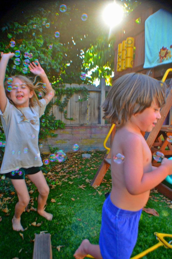 My kids blowing bubbles in our College Grove backyard.