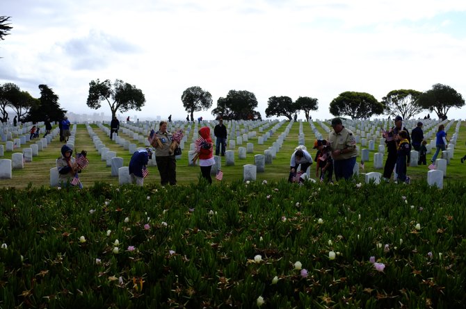San Diego, CA. Boy Scouts place flags on headstones at Ft. Rosecrans Cemetery in preparation for the Memorial Day holiday.  Boy Scouts, Girl Scouts and volunteers placed flags on more than 67,000 headstones Saturday from 7:45 to 9:30. 