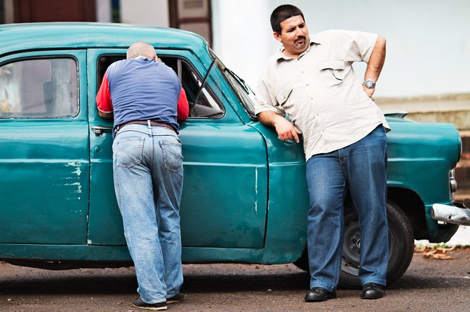 Two man standing beside an antique car in Havana, Cuba