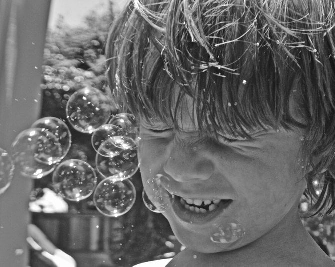 Fin, getting a faceful of bubbles (he asked for them). Our backyard. College Grove.