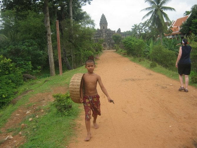 A young boy approaches from one of the Angkor temples in Cambodia.