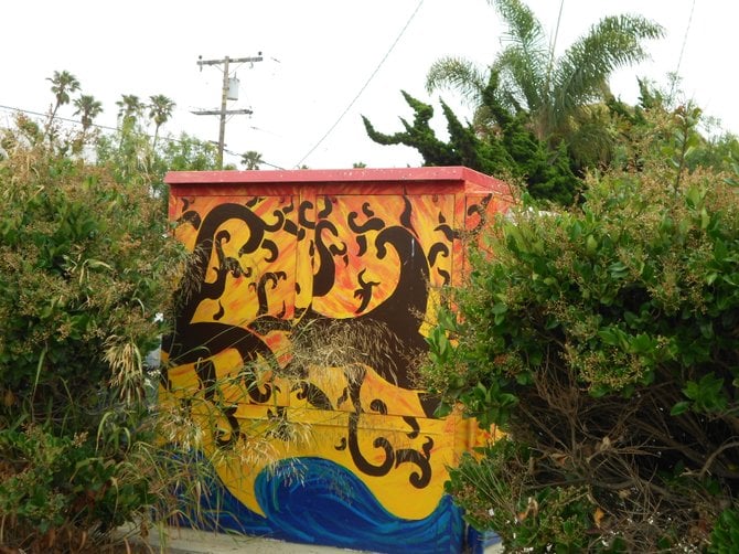 Overgrown plants and grass adorn this Cable Street utility box art in Ocean Beach.