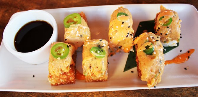 An appetizer of crispy rice with spicy tuna, serrano chili, and ponzu sauce.