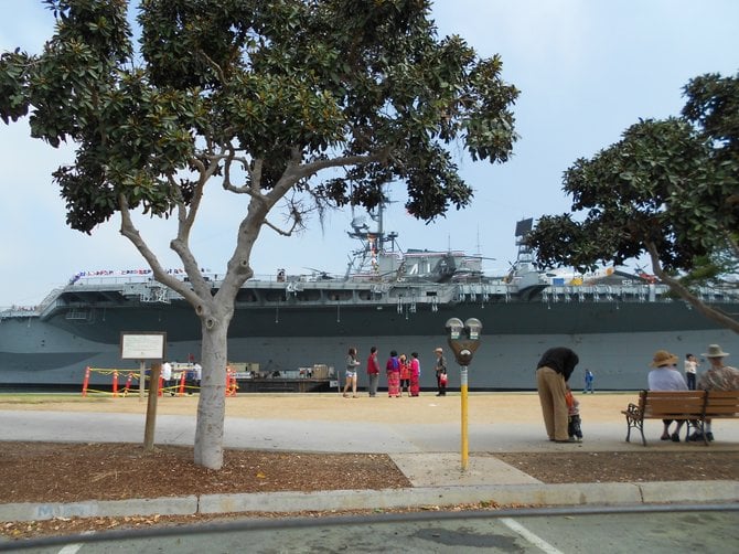 Tourists admire Midway Museum downtown.