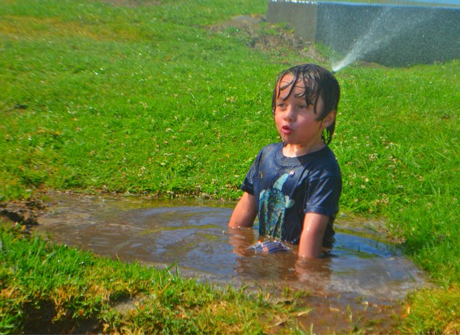 My son Fin sitting in a mud puddle of his own making at Mission Bay playground.
