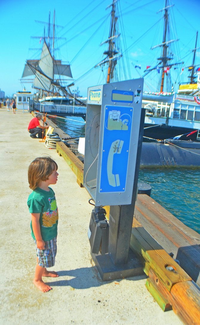 My son Fin, pondering a nearly extinct payphone