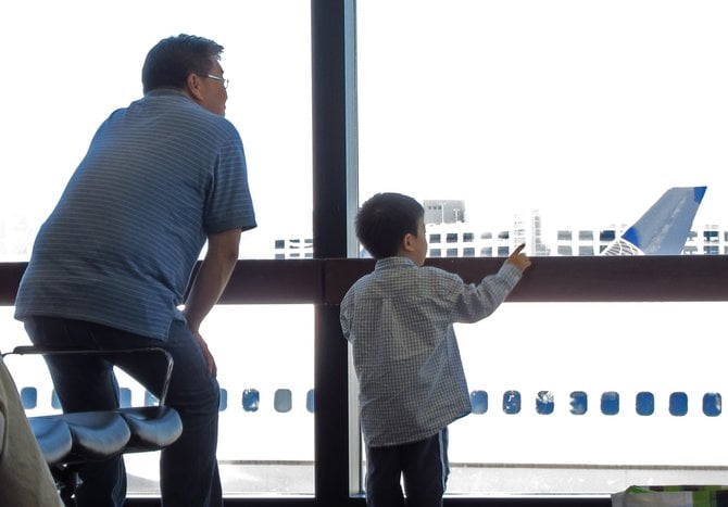 A father and son watch the planes at San Francisco airport