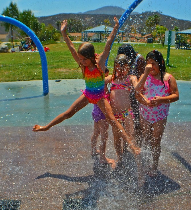 Aidan Hart jumps for joy at the Hilton Head Spray Park in Rancho San Diego