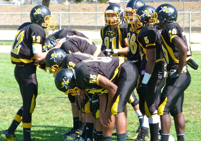 Mission Bay junior quarterback Nick Plum calls out the play in the huddle
