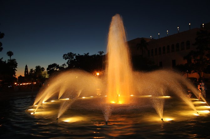 Fountain in Balboa Park, looking west, with the California Bell tower in the background at dusk.