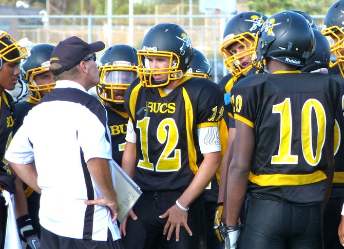 Mission Bay head coach Willie Matson talks to junior quarterback Nick Plum (12) and the Buccaneers offense during a timeout