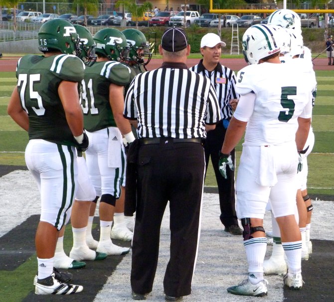 Poway and La Costa Canyon team captains meet at midfield for the coin toss