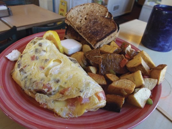 The Aswan Dam omelet features three eggs, gyro filling, red onions, tomato, and chunks of feta cheese.
