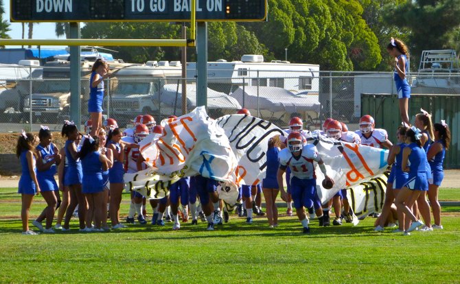Clairemont players charge through the banner after hafltime