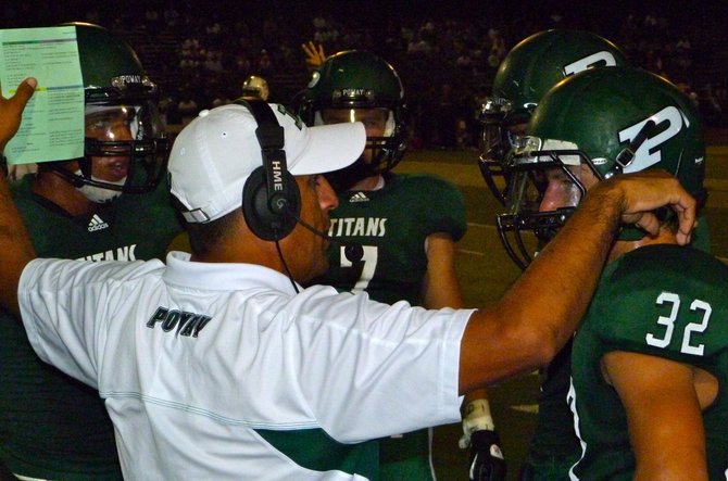 Poway head coach Damian Gonzalez give the play to four Titans players on the sidelines